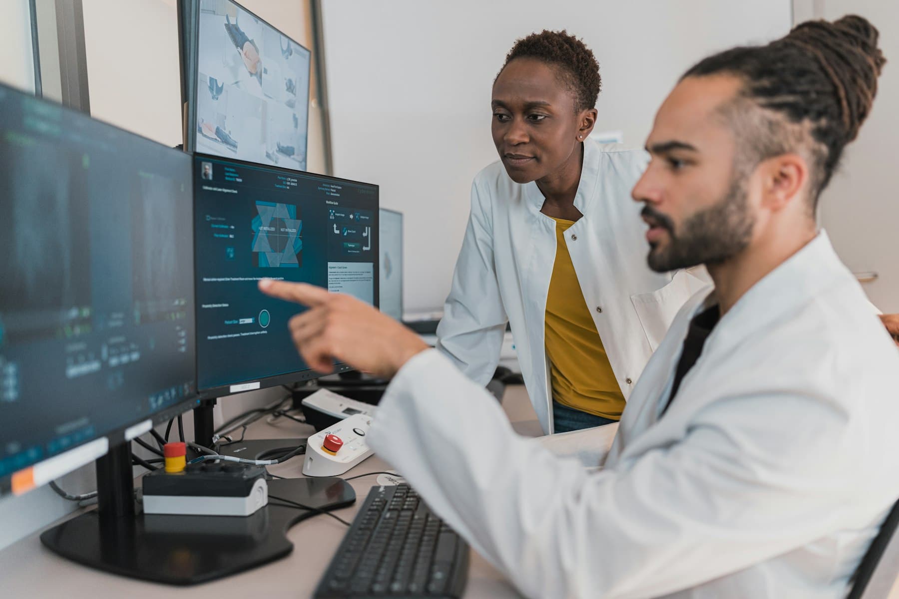 Clinicians reviewing diagnostic images on medical displays. Demonstration imagery — not Peak Mark staff.