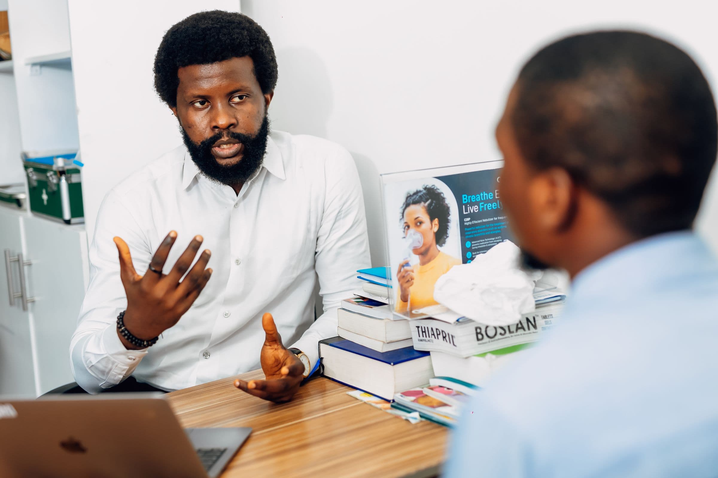 A healthcare professional consulting with an adult patient in a clinic. Demonstration imagery — not Peak Mark staff.